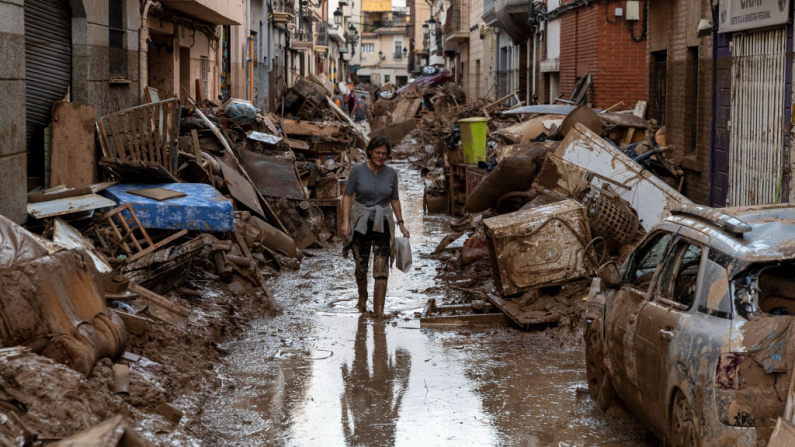 Una mujer camina por una calle llena de barro y desechos de las casas después de las fuertes lluvias e inundaciones que azotaron gran parte del país el 02 de noviembre de 2024 en el municipio de Paiporta, en Valencia, España. El intenso episodio de lluvias se conoce como «gota fría» o sistema meteorológico DANA. (Foto de Pablo Blazquez Dominguez/Getty Images)