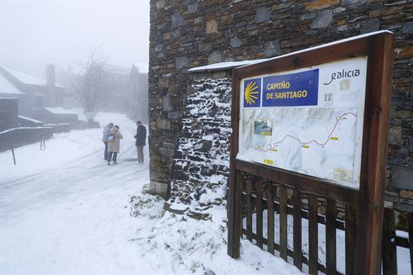 Varias personas pasan por O Cebreiro, Lugo, que está nevado. EFE/ Eliseo Trigo