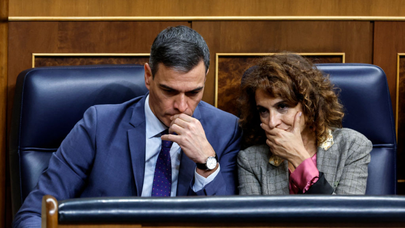 El presidente del Gobierno español, Pedro Sánchez (i), y la ministra de Presupuestos, María Jesús Montero, asisten a una sesión plenaria en el Congreso de los Diputados, en Madrid, el 21 de noviembre de 2024. (Foto de OSCAR DEL POZO / AFP) 