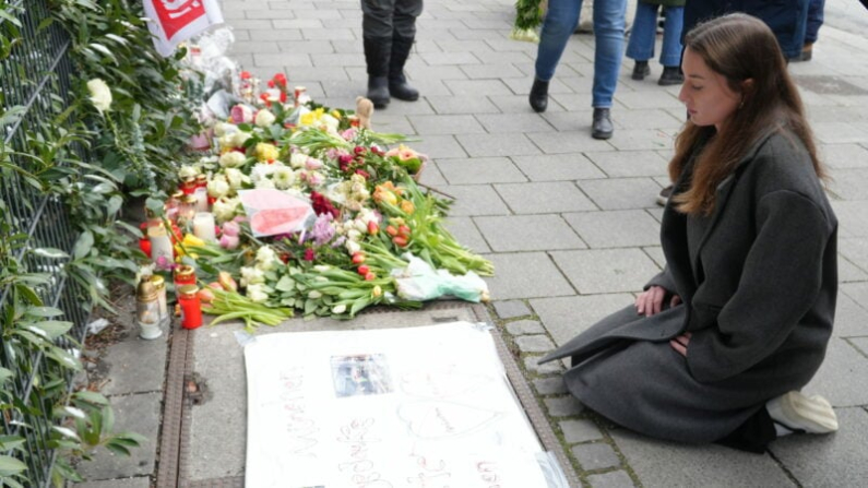 Alexa Gräf, testigo del ataque del 13 de febrero de 2025 en Múnich, se arrodilla frente a flores y velas en el lugar del ataque. (Foto: Epoch Times)