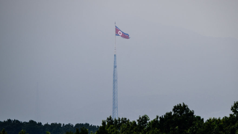 En esta imagen tomada desde Paju el 30 de julio de 2024, se ve una bandera norcoreana ondeando al viento en la aldea de Gijungdong en Corea del Norte. (Anthony Eallace/AFP vía Getty Images)