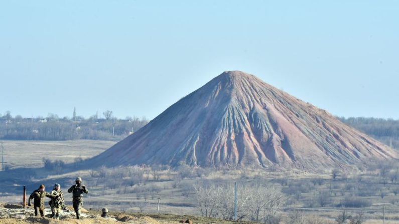 Soldados frente a un montón de escombros de una mina de carbón en la posición de primera línea de las fuerzas ucranianas cerca de la pequeña ciudad de Kurakhove, región de Donetsk, el 11 de marzo de 2015. (SERGEI SUPINSKY/AFP vía Getty Images)