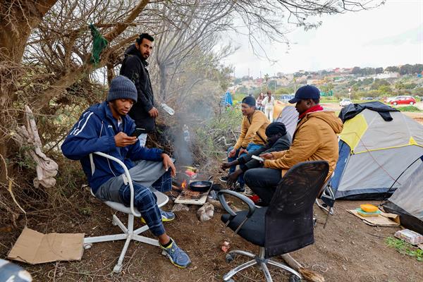 Un total de 14 solicitantes de asilo procedentes de varios países latinoamericanos y de Mali acampan junto al Centro de Estancia Temporal de Inmigrantes (CETI) de Melilla tras no ser admitidos en estas instalaciones del Ministerio de Inclusión, Seguridad Social y Migraciones el 2 de marzo de 2025. (EFE/ Giner)