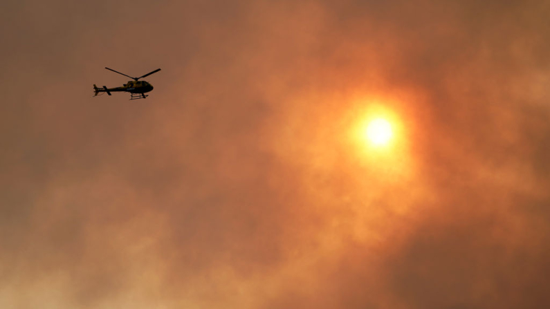 Un helicóptero de vigilancia sobrevuela una zona mientras los incendios arden en Posada, en la región norteña de Asturias, el 5 de marzo de 2019. (Cesar Manso / AFP vía Getty Images)