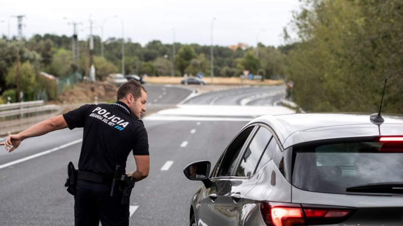 Imagen de archivo. Un policía habla con un conductor mientras la carretera está cerrada después de que un río se desbordara debido a las fuertes lluvias (Curto de la Torre / AFP vía Getty Images)