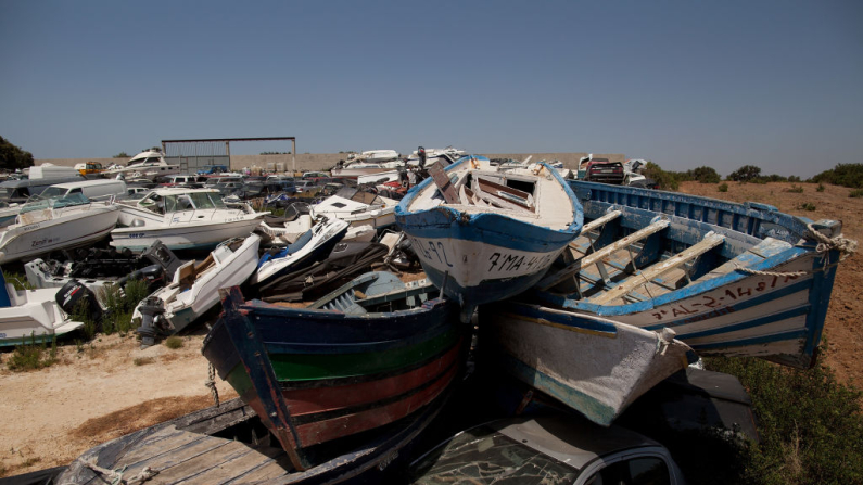 Pequeñas embarcaciones de madera, conocidas como "pateras", utilizadas para la inmigración ilegal, se almacenan en un patio junto con otros vehículos utilizados para el narcotráfico a la espera de juicios, cerca de Chiclana de la Frontera, provincia de Cádiz, Andalucía, España. Imagen de archivo. (Pablo Blazquez Dominguez/Getty Images)