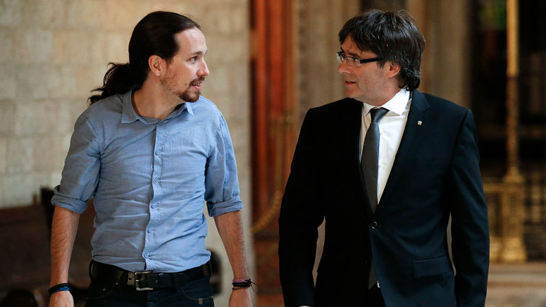 El presidente de la Generalitat de Cataluña, Carles Puigdemont (izquierda), camina con el líder del partido Podemos, Pablo Iglesias, para celebrar una reunión en el palacio de la Generalitat en Barcelona el 8 de abril de 2016. (Pau Barrena/AFP a través de Getty Images)