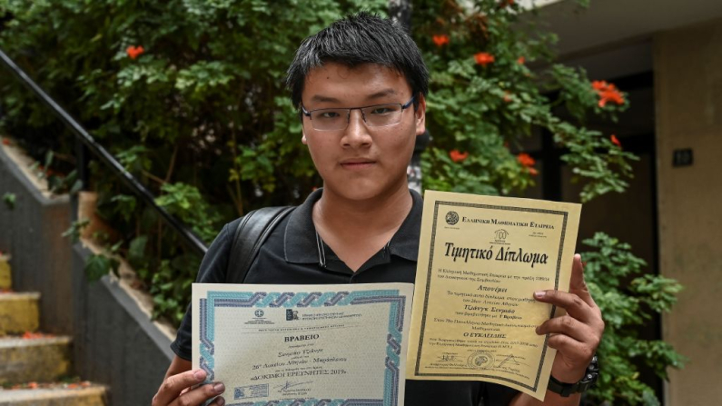 Jiang Semniao, de 18 años, posa sosteniendo sus diplomas en el centro de Atenas el 31 de octubre de 2019. El acuerdo de visa dorada otorga a los ciudadanos no pertenecientes a la UE un permiso de residencia de cinco años a cambio de invertir en bienes raíces. Miembros afectados por la crisis ecoómica, como Grecia, Portugal, Chipre y España, han estado ofreciendo incentivos similares durante años. Aris Messinis / AFP vía Getty Image)
