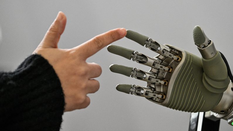 Una mujer toca una mano robótica de OY Motion durante la conferencia mundial de desarrolladores, organizada por la Asociación de la Industria de la Inteligencia Artificial de Shanghái, en Shanghái, el 21 de febrero de 2025. (HECTOR RETAMAL/AFP a través de Getty Images)

