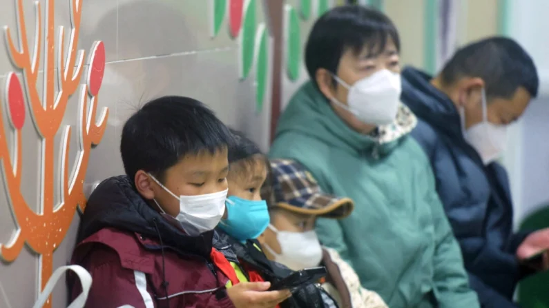 Niños enmascarados, acompañados por adultos, esperan a ser atendidos por el personal médico en el departamento de pediatría de un hospital en Hangzhou, provincia de Zhejiang, en el este de China, el 6 de enero de 2025. AFP a través de Getty Images
