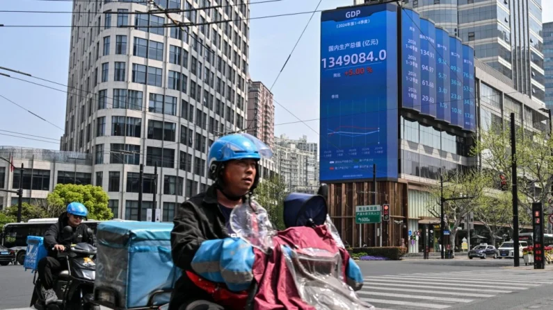 Conductores pasan frente a una pantalla que muestra el producto interior bruto (PIB) en el distrito de Jing'an, en Shanghái (China), el 9 de abril de 2025. Héctor Retamal/AFP a través de Getty Images.

