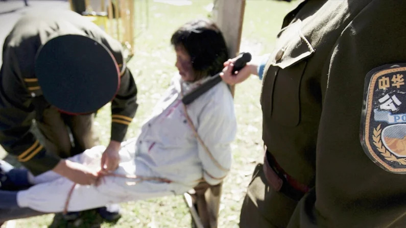 Una recreación de la tortura infligida a un practicante de Falun Gong durante un acto conmemorativo del sexto aniversario del inicio de la persecución contra Falun Gong, el 20 de julio de 2005 en Sídney (Australia). Ian Waldie/Getty Images
