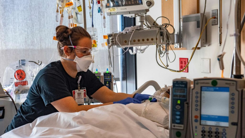 Un profesional médico atiende a un paciente sin COVID-19, quien se encuentra en una habitación junto a otras con pacientes con COVID-19, en la UCI del Centro Médico UMass Memorial en Worcester, Massachusetts, el 4 de enero de 2022. (Foto de Joseph Prezioso / AFP) (Foto de JOSEPH PREZIOSO/AFP vía Getty Images)