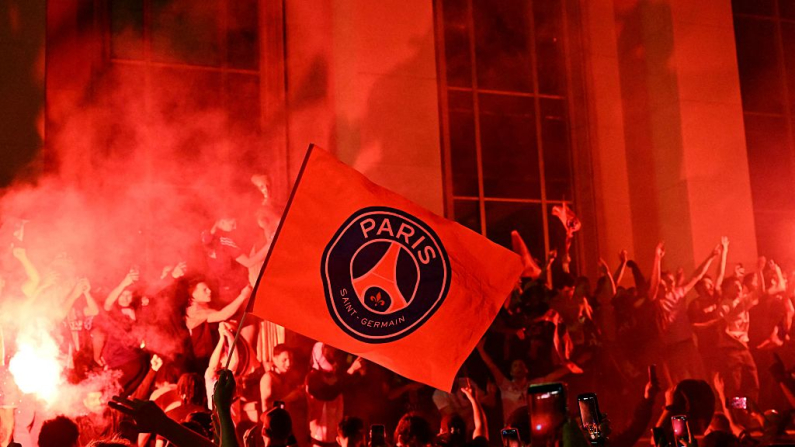 Los aficionados del Paris Saint-Germain (PSG) encienden bengalas al congregarse en la plaza Trocadero, frente a la Torre Eiffel, en París, el 31 de mayo de 2025, durante las celebraciones tras su victoria por 5-0 en la final de la UEFA Champions League entre el Paris Saint-Germain (PSG) y el Inter de Milán. (Hugo Mathy / AFP vía Getty Images)