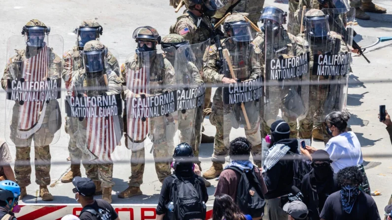 
Manifestantes se enfrentan a agentes federales y miembros de la Guardia Nacional de California en Los Ángeles el 8 de junio de 2025. John Fredricks/The Epoch Times

