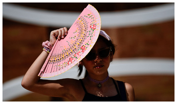 Una mujer se protege del Sol con un abanico durante la primera ola de calor del verano en Sevilla, el 28 de junio de 2025. El sur de Europa se enfrenta a temperaturas extremas superiores a los 40 °C. (Cristina Quicler/ AFP vía Getty Images)