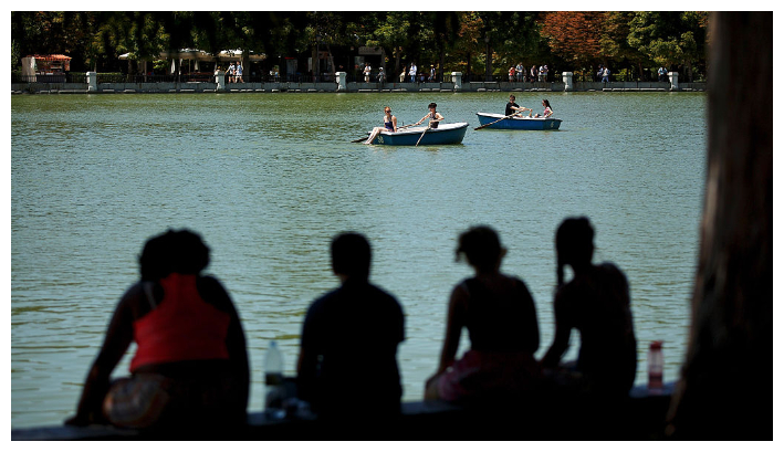 Mujeres sentadas a la sombra observan a la gente remar en un bote en el Parque del Retiro. Imagen de archivo. (Pablo Blázquez Domínguez/Getty Images)