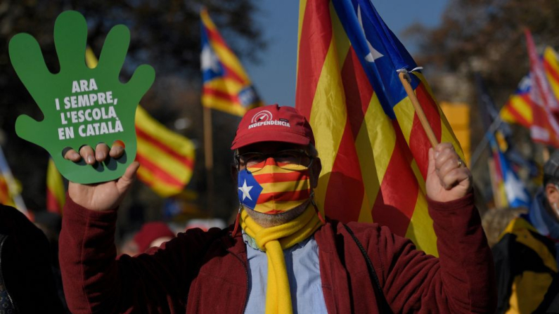 Un manifestante sostiene un cartel con la leyenda «Ahora y siempre, escuela en catalán» durante una manifestación convocada para defender el modelo lingüístico de las escuelas catalanas, donde todas las asignaturas se imparten en catalán, en Barcelona el 18 de diciembre de 2021. (Foto de Pau BARRENA / AFP) (Foto de PAU BARRENA/AFP vía Getty Images)