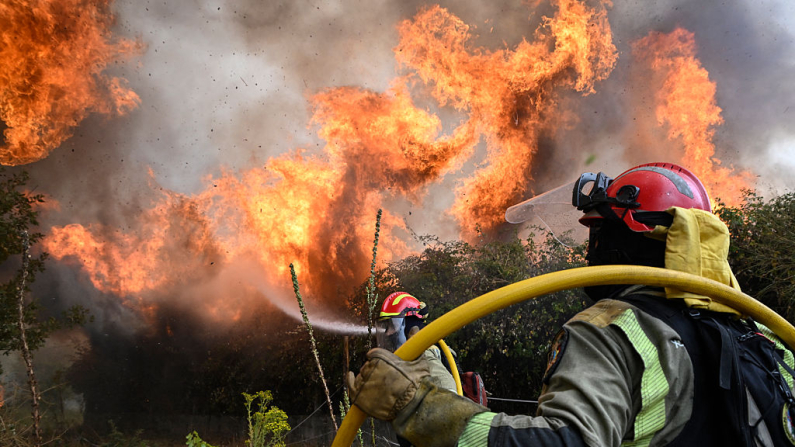Un bombero cae al suelo mientras trabaja para extinguir un incendio forestal en San Cibrao das Viñas, a las afueras de Orense, en el noroeste de España, el 12 de agosto de 2025. (Foto de MIGUEL RIOPA / AFP) (Foto de MIGUEL RIOPA/AFP a través de Getty Images)