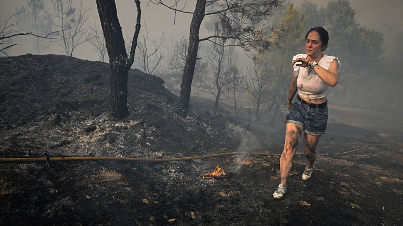 Una mujer intenta extinguir un incendio forestal cerca del pueblo de Larouco, en la provincia de Orense, en el noroeste de España, el 13 de agosto de 2025. Los bomberos continúan combatiendo incendios en todo el país, donde un voluntario falleció mientras intentaba extinguir un incendio, según las autoridades locales. Otro hombre falleció por quemaduras cerca de la capital, Madrid. (Miguel Riopa/ AFP vía Getty Images)