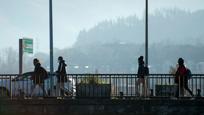 Cuatro migrantes intentan cruzar el puente fronterizo hispano-francés de Santiago, entre Irún (España) y Hendaya (Francia). Imagen de archivo. (Ander Gillenea /AFP vía Getty Images)