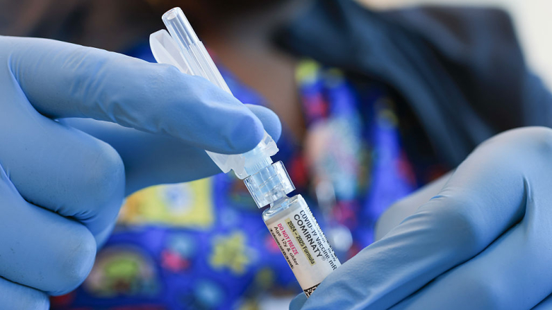 En esta ilustración fotográfica, Ruth Jones, enfermera de inmunización, sostiene una vacuna contra la COVID-19 de Pfizer-BioNTech (marca: Comirnaty) en el Centro de Salud Borinquen el 29 de mayo de 2025 en Miami, Florida. El secretario de Salud, Robert F. Kennedy Jr., anunció que ya no recomendará la vacunación contra la COVID-19 para niños sanos y mujeres embarazadas. (Ilustración fotográfica de Joe Raedle/Getty Images)