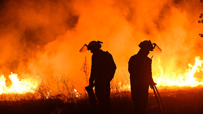 Bomberos trabajan para extinguir un incendio forestal en el pueblo de Vilaza, cerca de Verín, provincia de Orense, noroeste de España, el 12 de agosto de 2025. (Foto de MIGUEL RIOPA / AFP) (Foto de MIGUEL RIOPA/AFP vía Getty Images)