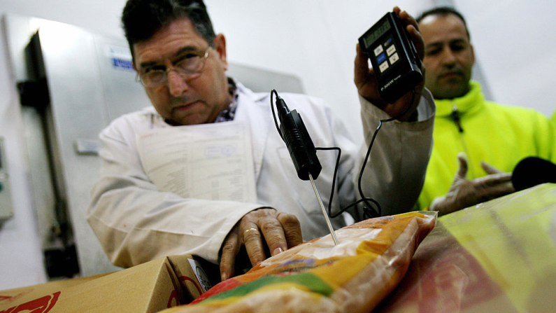 Un empleado del Servicio de Salud de la inspección en España utiliza un dispositivo especial para medir la temperatura durante una inspección rutinaria de un contenedor de pechugas de pollo procedente de Brasil con destino a la Unión Europea. (Jose Luis Roca/AFP vía Getty Images)