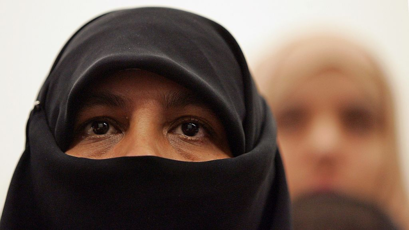Una mujer musulmana con niqab escucha durante un seminario organizado por la sección femenina de Hizb-ut-Tahrir Britain para cuestionar las declaraciones de Jack Straw y otros ministros británicos contra el velo el 14 de octubre de 2006 en Londres, Inglaterra. El líder de la Cámara de los Comunes británica, Jack Straw, había comentado que, según él, velos como el burka y el niqab dividen a las comunidades. (Foto de Scott Barbour/Getty Images)