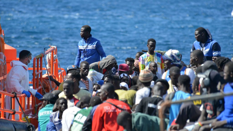 Los equipos de primera respuesta y los miembros de la Cruz Roja atienden a los migrantes que desembarcan de un barco en el muelle de La Restinga, en el municipio de El Pinar, en la isla canaria de El Hierro, el 21 de octubre de 2023. (Foto de STRINGER / AFP) (Foto de STRINGER/AFP a través de Getty Images)