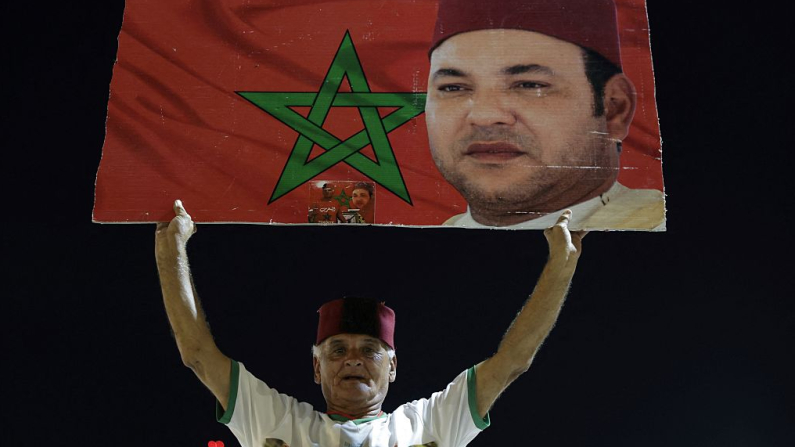 Un marroquí sostiene una imagen del rey Mohammed VI mientras la gente celebra la decisión del Consejo de Seguridad de la ONU, que expresó su apoyo al plan de autonomía de Marruecos para el Sáhara Occidental, territorio disputado durante medio siglo entre Rabat y el Frente Polisario, que busca la independencia y cuenta con el respaldo de Argelia. La celebración tuvo lugar en Rabat, a última hora del 31 de octubre de 2025. (Photo by Abdel Majid BZIOUAT / AFP) (Photo by ABDEL MAJID BZIOUAT/AFP via Getty Images)