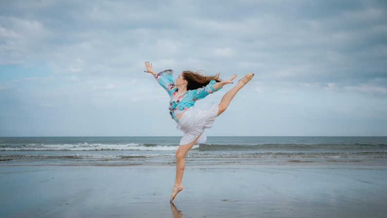 Una mujer realiza un movimiento de danza a orillas del mar. innokurnia. Pixabay