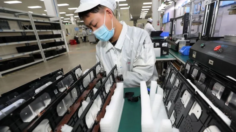Un trabajador de una fábrica de Xinwangda Electric Vehicle Battery Co. Ltd., empresa que fabrica baterías de litio para coches eléctricos y otros usos, en Nanjing, provincia de Jiangsu, al este de China, el 12 de marzo de 2021. STR/AFP vía Getty Images