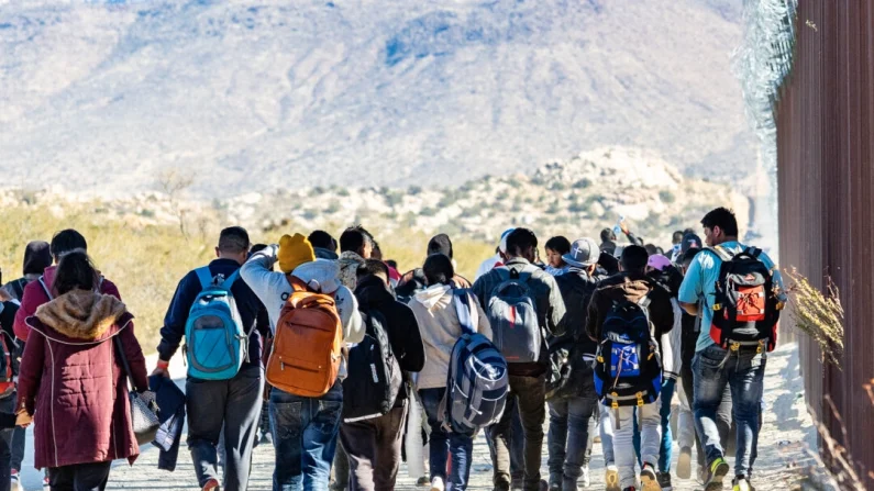 Inmigrantes indocumentados esperan ser procesados ​​por agentes de la Patrulla Fronteriza de EE. UU. en las afueras de San Diego, California, el 5 de diciembre de 2023. John Fredricks/The Epoch Times