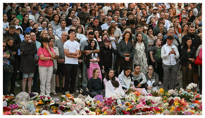 Personas en duelo se reúnen en un homenaje frente al Bondi Pavilion, en Bondi Beach, para recordar a las víctimas de un tiroteo ocurrido el 15 de diciembre de 2025 en Sídney, Australia. Según informaron las autoridades ese mismo día, un padre y su hijo abrieron fuego durante un festival judío en Bondi Beach en un ataque calificado como terrorismo antisemita, que dejó 15 personas muertas, incluido un niño. Foto: Saeed Khan / AFP vía Getty Images.